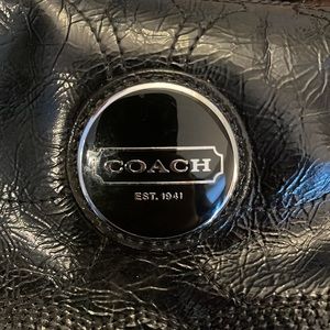 Black patent leather coach bag.